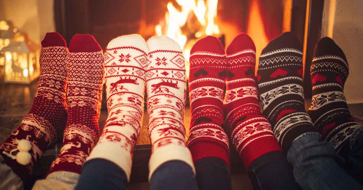 Four pairs of holiday socks by the fireplace