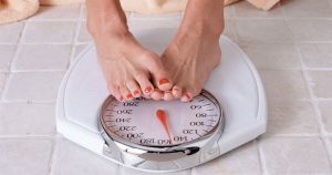 A person is standing on a weight scale