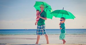 Family walking on the beach with an umbrella