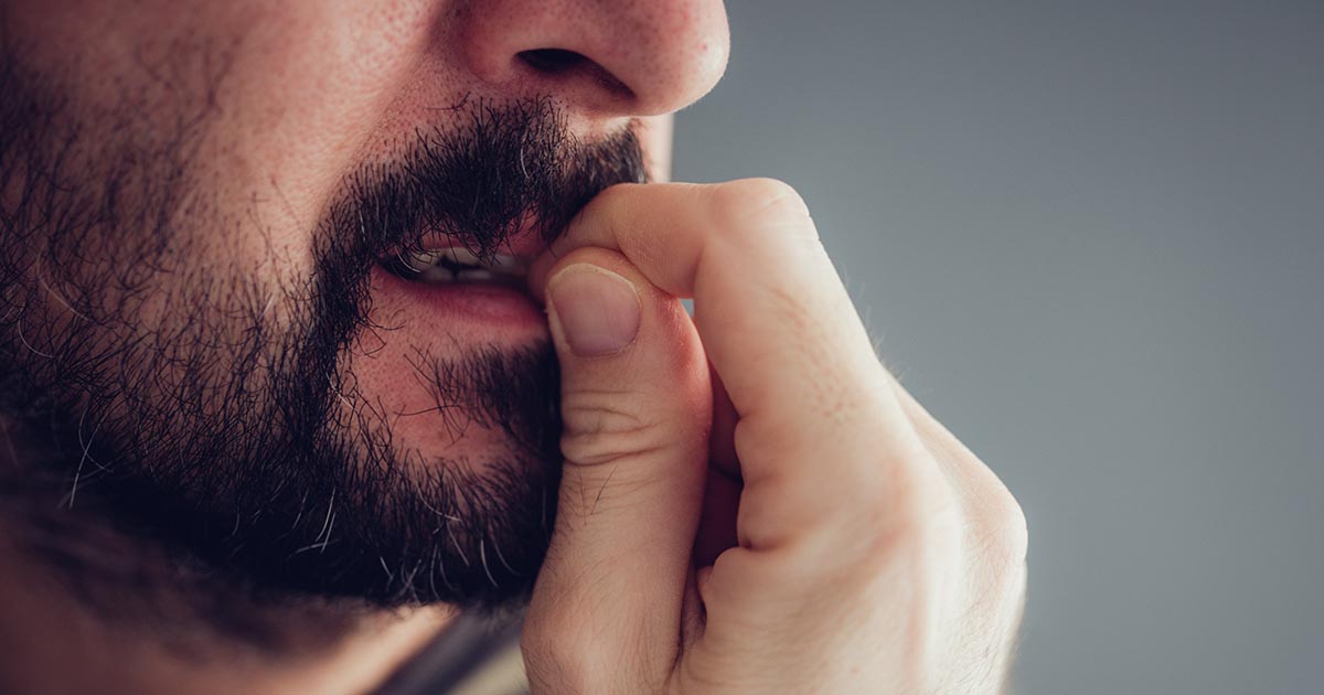 A man is anxiously biting his nails