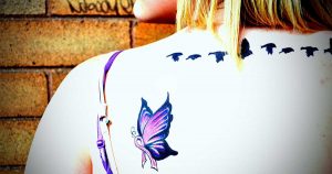 a purple butterfly and ribbon, an example of a lupus tattoo